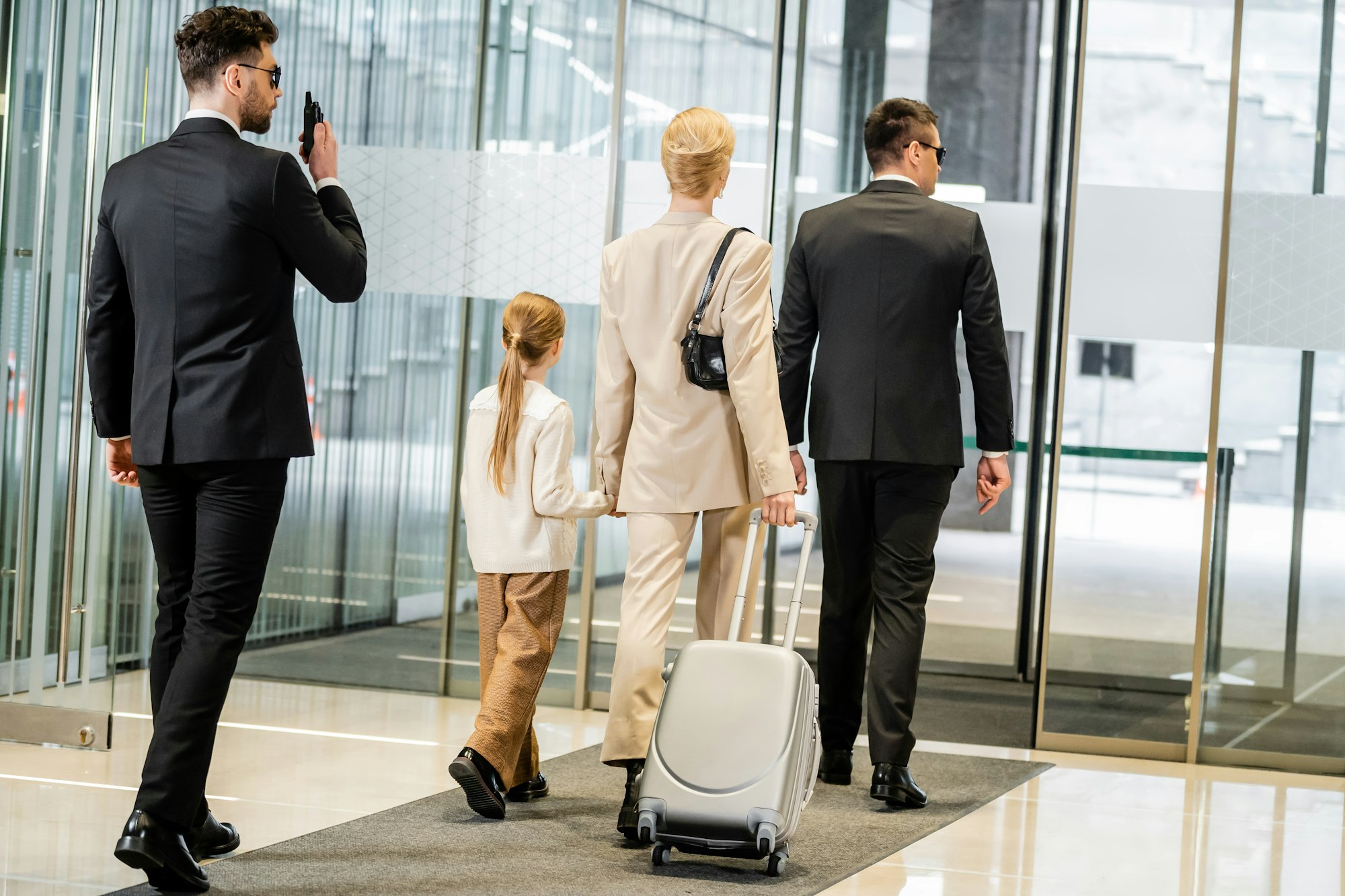 personal protection, bodyguard communicating through walking talkie and escorting blonde woman